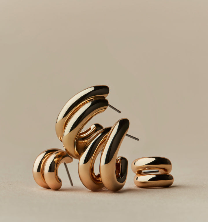 Gold toned hoop earrings styled in a clean studio scene on GLAMBOU CH
